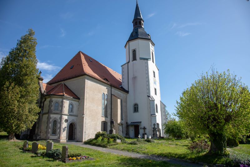 Außenansicht der Kirche und einzelne Gräber in Seifersdorf